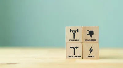 Concept of SWOT analysis and strategic planning technique. Strengths, weaknesses, threats and opportunities. SWOT symbols on wooden cubes with beautiful grey background