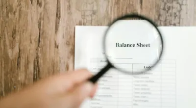 Magnifying Glass inspecting a balance sheet