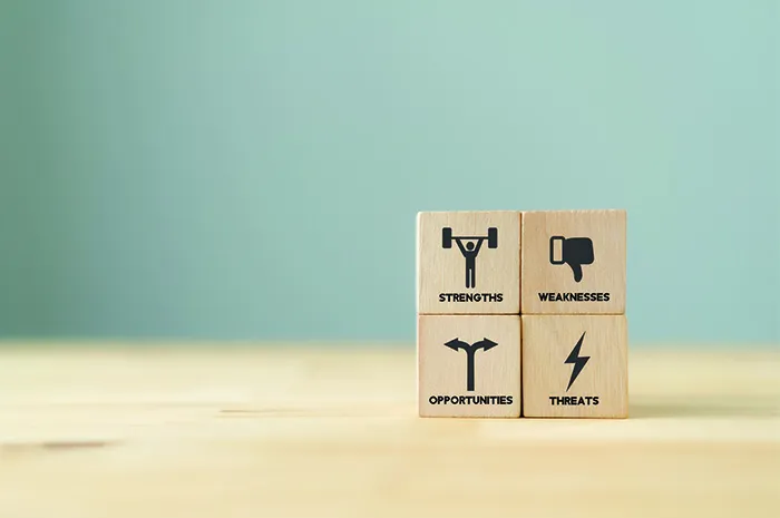 Concept of SWOT analysis and strategic planning technique. Strengths, weaknesses, threats and opportunities. SWOT symbols on wooden cubes with beautiful grey background